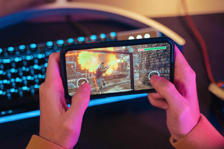 Person playing a video game on a smartphone.