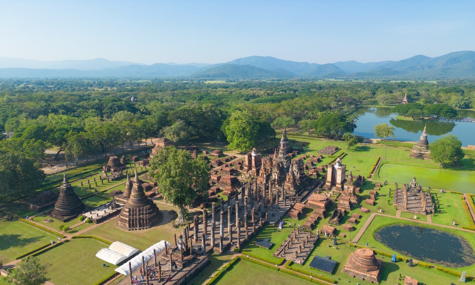 <p><span>Sukhothai, the first capital of Thailand, is where Thai art, architecture, and language began to develop and flourish. The Sukhothai Historical Park, a UNESCO World Heritage Site, is an archaeological delight with well-preserved ruins and majestic Buddha statues set amidst scenic lakes and gardens.</span></p> <p><span>Exploring this ancient city on a bicycle offers a leisurely and intimate experience of the park’s vast grounds. Highlights include Wat Mahathat, with its impressive central stupa, and Wat Si Chum, known for its gigantic seated Buddha.</span></p> <p><span>The historical significance of Sukhothai, coupled with its serene and picturesque setting, provides a profound insight into the origins of Thai culture and the nation’s early history.</span></p> <p><b>Insider’s Tip: </b><span>Visit during the Loy Krathong festival in November, when the park is beautifully lit with lanterns.</span></p> <p><b>How To Get There: </b><span>Sukhothai is accessible by bus or plane from Bangkok and Chiang Mai.</span></p> <p><b>Best Time To Travel: </b><span>The cool season is the best time to visit, especially around the Loy Krathong festival.</span></p>