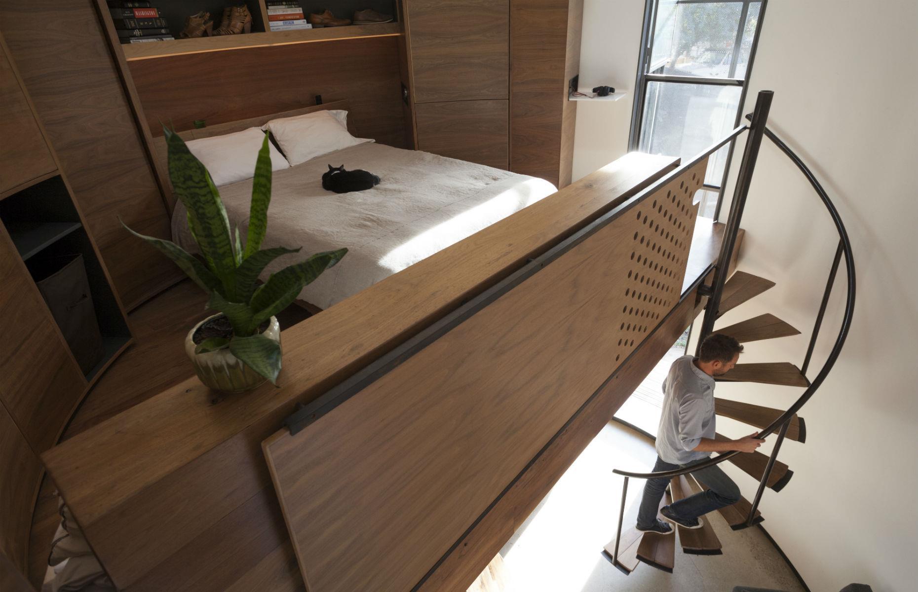 <p>With just 340 square feet to work with, every space needed a purpose, so Christoph opted to use the full height and volume of the silo, creating an arc of units against one wall to free up the remaining floor area.</p>  <p>A space-saving spiral staircase leads to the mezzanine bedroom, which offers standing room at either side of the bespoke bed, while the home's bijou bathroom includes a shower, a basin and a toilet.</p>