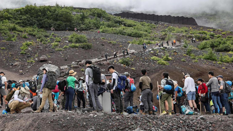 This 2023 photo shows a crowd of visitors beginning their Mount Fuji ascents. - Mathiad Cena/AFP/Getty Images
