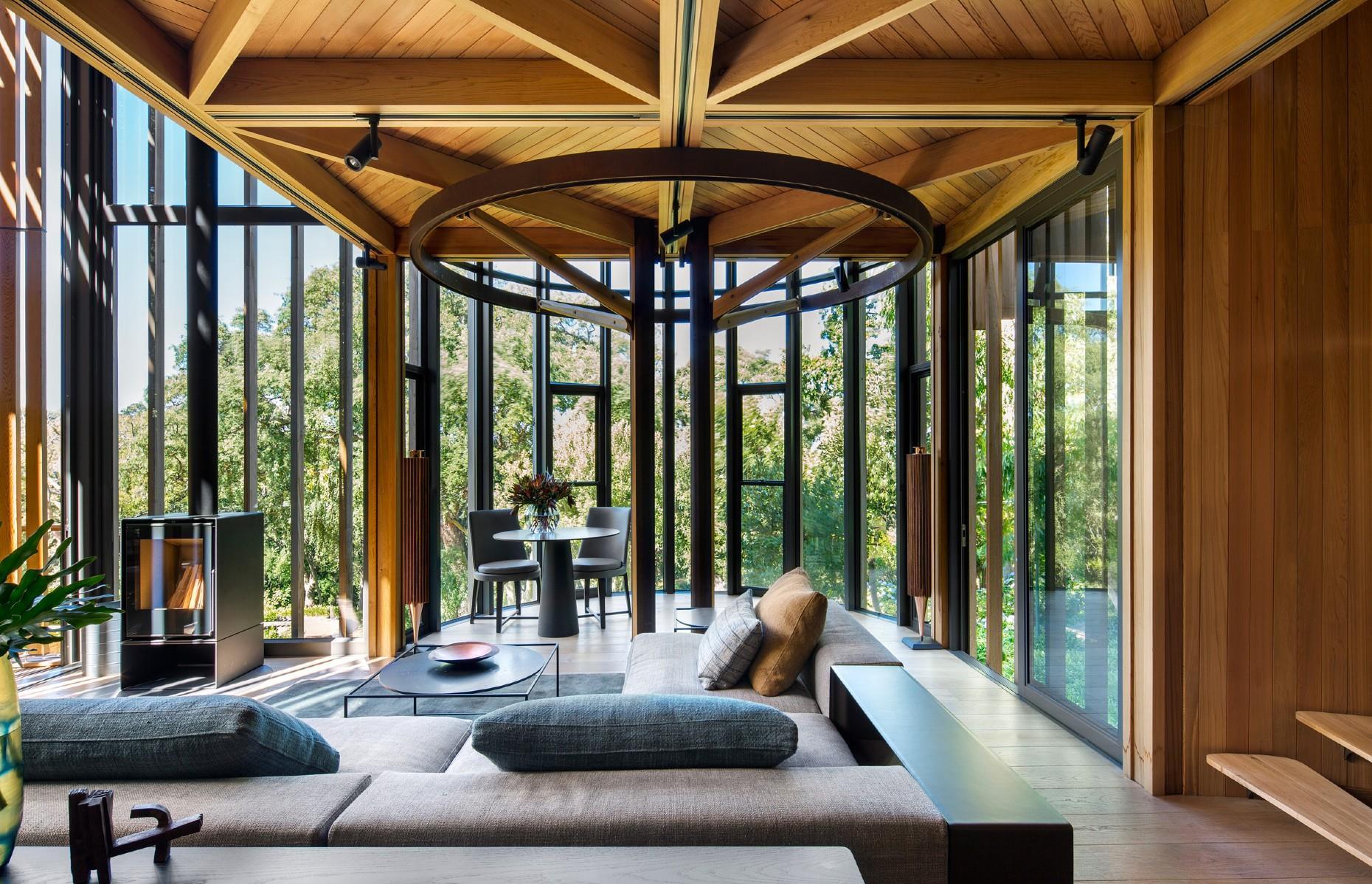 <p>Offering a unique "pin-wheel plan layout", the treehouse gains support from columns, arms and rings constructed from laser-cut and folded Corten steel plates, which are connected to the natural timber floors by brass bolts.</p>  <p>A spectacular living area and kitchen occupy the first floor of the house. A neutral palette allows the warmth of the cedar and the stunning treetop views to do all the talking, while the black lines of the furnishings echo the industrial beams that frame the windows.</p>
