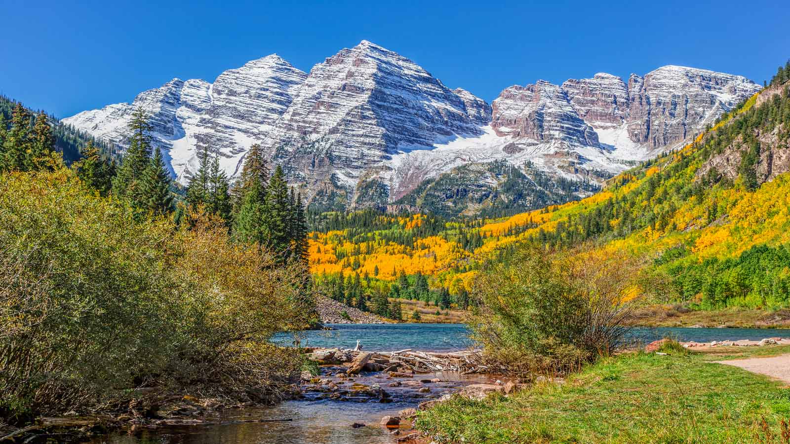 <p>Most people think of Colorado as a winter destination. After all, those snow-capped mountains are primed for skiing and snowboarding – but it’s a great place to visit at any time of year.</p><p>During the fall, in particular, the state is filled with golden yellows and rusty oranges thanks to the changing leaves and chilling temperatures.</p><p>The <a href="https://thehappinessfxn.com/how-to-visit-colorado-maroon-bells/">Maroon Bells</a> are one of the best places to see fall colors in Colorado. With the fire-colored leaves, striking mountain peaks, and mirroring lake, it’s picture-perfect.</p>