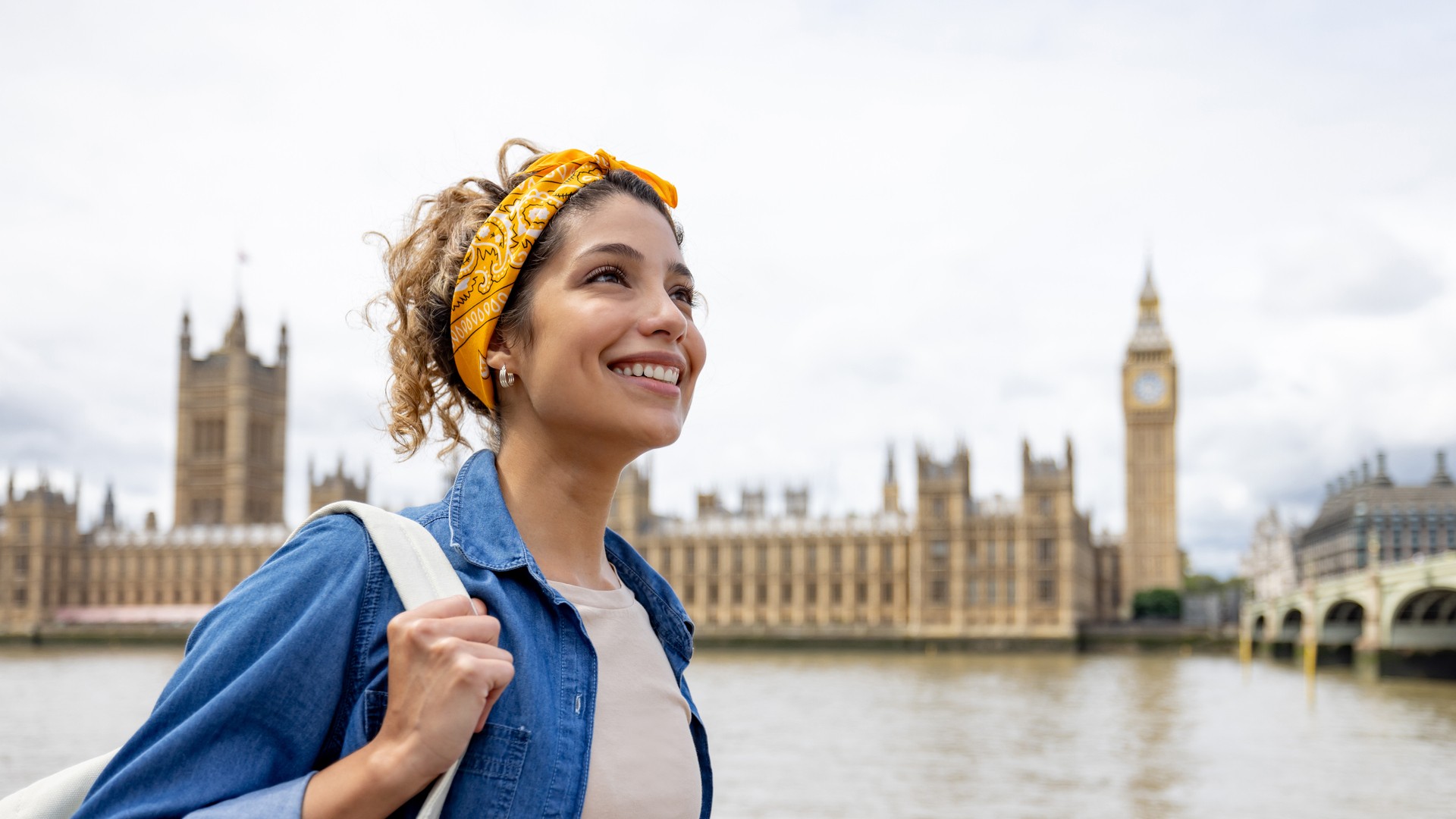 a woman smiles as she travels the world iStock-1597406578