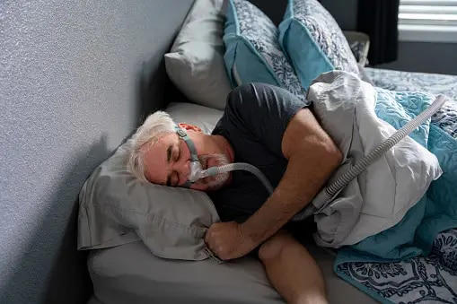 A man sleeps with a CPAP machine. (Photo: Unsplash)