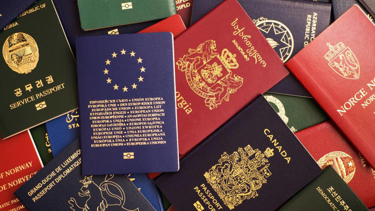 Passports from different countries are displayed on a flat surface. -lead