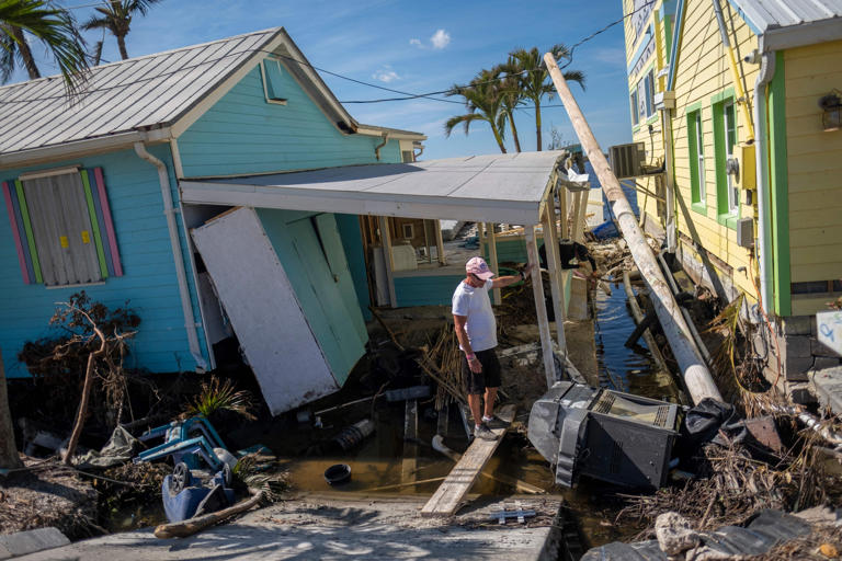 A man stands in front of his destroyed house in the aftermath of Hurricane Ian in Matlacha, Florida on October 3, 2022. Florida has a higher number of damaged properties currently on sale than either California or Texas.