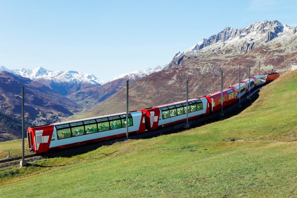 <p>Known as the ‘slowest express train in the world,’ the Glacier Express offers a panoramic journey through the Swiss Alps, connecting Zermatt and St. Moritz. The train’s panoramic carriages provide unobstructed views of Switzerland’s dramatic landscapes, including deep gorges, soaring peaks, and pristine lakes.</p> <p>Onboard, enjoy a three-course meal while traversing some of the most breathtaking scenery in Europe. The journey is a testament to the beauty of slow travel for those who simply want to sit back and relax as they take in the beauty of Switzerland.</p>