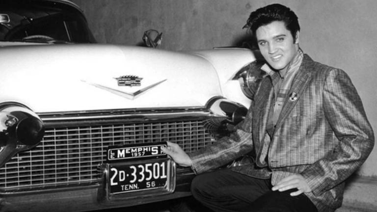 Elvis Presley next to one of his cars.