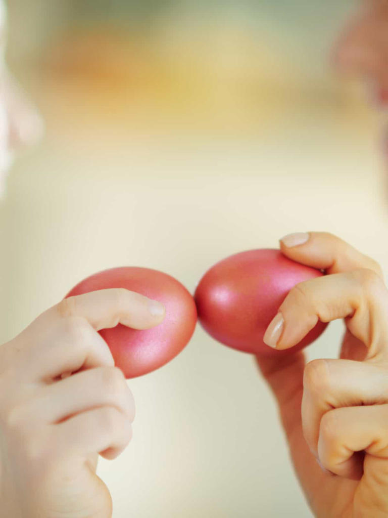 Closeup on tapping with red Easter eggs playing a game of Tsougrisma, the Greek Easter egg game.