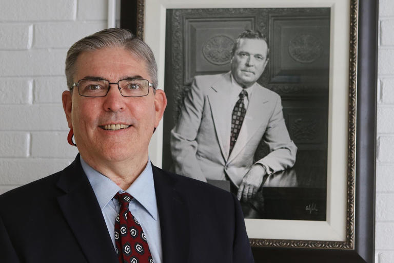 Head of School Richard Rankin, poses in front of a portrait of Founding Head of School, Mr. J. B. Davis, at Gaston Day School on Aug. 23, 2017.