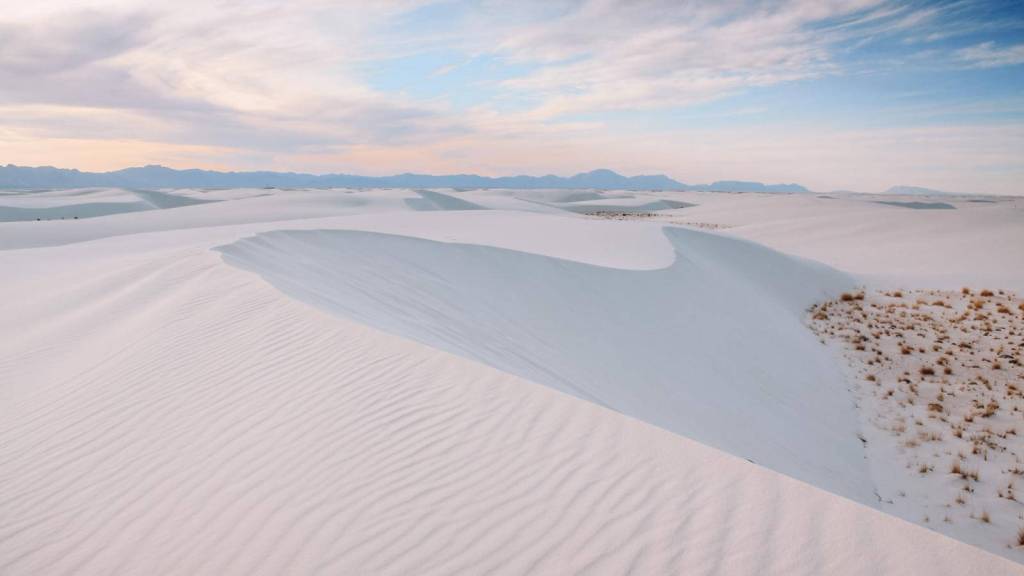 <p>If you are into the extraordinary, then visiting White Sands in New Mexico should be an entry on your bucket list. This desert landscape features striking white dunes that go on for miles and miles. We do not get to see white desert sands and dunes every day, making it an excellent reason to visit White Sands. </p><p>With its uniqueness and beauty, this destination is a perfect spot for photographers, especially with the ever-changing shapes of the dunes. For perfect shots, visit around sunrise or sunset, as the views are more magical. If you enjoy outdoor activities, consider hiking the Alkali Flat Trail or Interdune Boardwalk for an immersive experience.</p><p class="has-text-align-center has-medium-font-size">Read also: <a href="https://worldwildschooling.com/us-national-parks/">US National Parks</a></p>