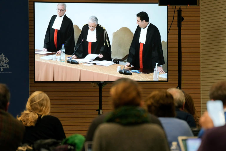 Reporters watch a screen in the Vatican press room showing Vatican tribunal president Giuseppe Pignatone reading the verdict of a trial against Cardinal Angelo Becciu and nine other defendants (Copyright 2023 The Associated Press. All rights reserved)