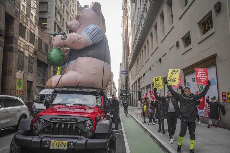 MLS referees and supporters picket outside MLS headquarters in New York around a "Greedy Pig" balloon on Feb. 21. The MLS implemented a lockout after the Professional Soccer Referees Assn. rejected a contract offer. ((Bebeto Matthews / Associated Press))