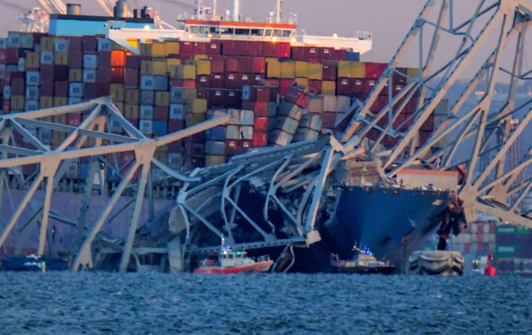 Emergency boats float around a container ship whose bow received damage after the Francis Scott Key Bridge crumbled onto the vessel and into the Patapsco River following a collision with the structure overnight.