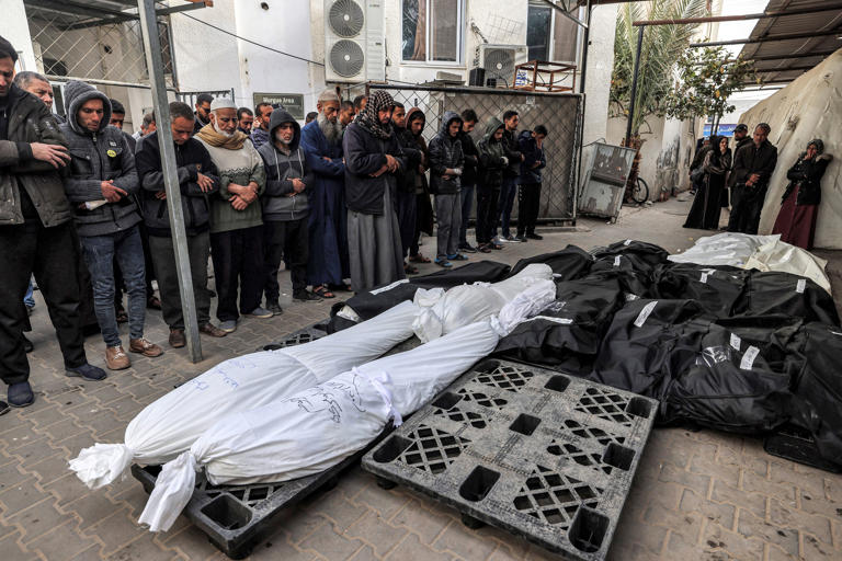 People perform funeral prayers over the bodies of victims killed during Israeli bombardment.