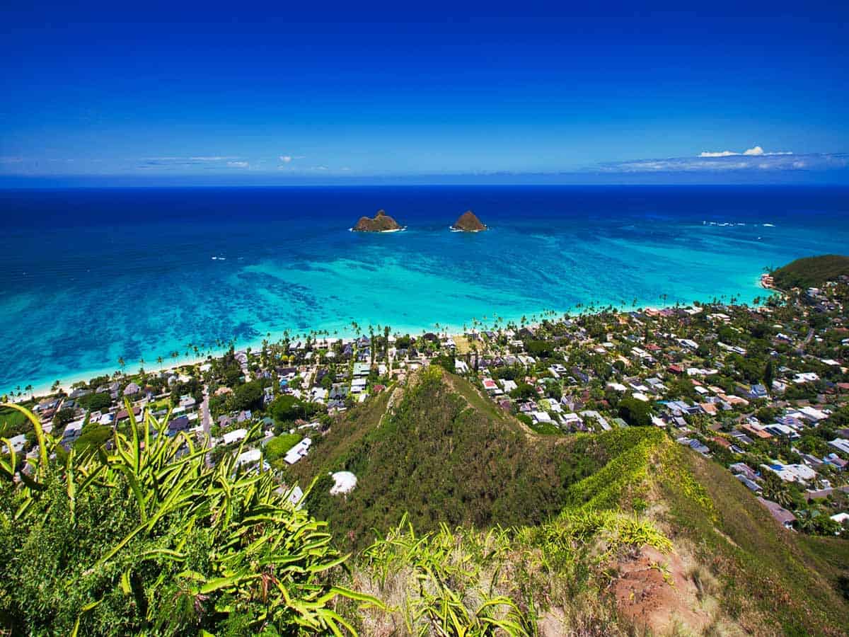 <p>The Lanikai Pillbox Hike might be my favorite hike in Hawaii. This short 1.7-mile round-trip trail takes you to some of the best views on the island. While some sections can be quite steep, this hike is doable as long as you take breaks.</p><p>At the end of it all, you’ll find the first of the Lanikai pillboxes. What’s a pillbox, you ask? They’re old military bunkers that boast fabulous views. While you can continue to a couple more pillboxes along this trail, you only need to go to the first one to get the full experience.</p><p>From the first pillbox, you’ll see a beautiful view of a sunny sky, the bright blue Pacific Ocean, and two bright green, postcard-worthy islands known as the Mokulua Islands. Naturally, you’ll inevitably start filling up your camera roll with these unbeatable views. This is one of the <a href="https://thehappinessfxn.com/best-hikes-in-oahu/">best hikes in Oahu</a>.</p>