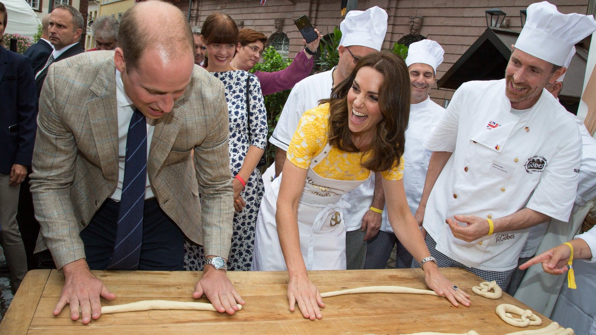 <p>                     During their 2017 tour of Germany and Poland, William and Kate got a hands-on lesson in some traditional treat making.                   </p>                                      <p>                     The couple took part in a class teaching how to hand-roll pretzels at a market in Heidelberg.                   </p>                                      <p>                     Dressed in a bright yellow lace dress, Kate's outfit was protected by an apron that translated to read, "We're baking for William and Kate", <a href="https://news.yahoo.com/kate-middleton-got-schooled-pretzel-195600620.html">per Yahoo</a>.                   </p>                                      <p>                     Kate, ever the competitive one, was said to have dove right in, proving a natural and enjoying a cheeky laugh at her husband, who struggled to get into the swing of things. You could say he got himself all twisted up like a pretzel...                   </p>