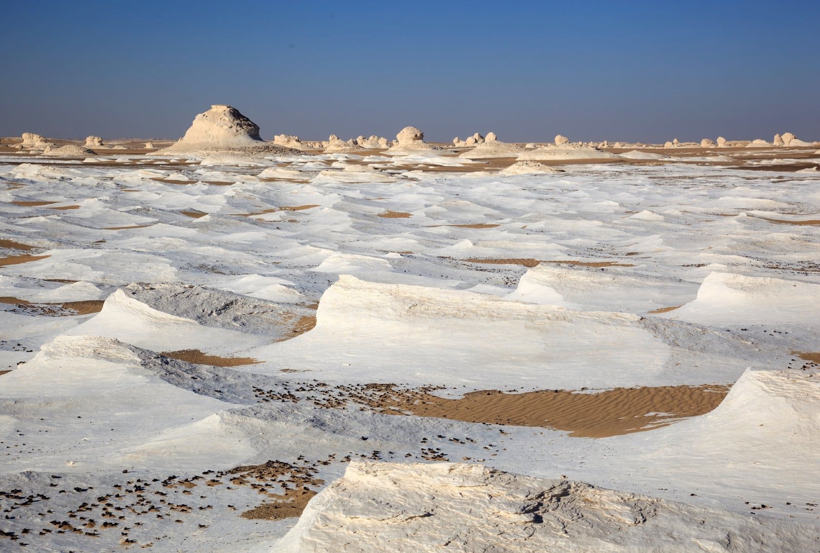 <p class="wp-caption-text">Image Credit: Shutterstock / kataleewan intarachote</p>  <p><span>The White Desert National Park, located roughly midway between Farafra and Bahariya Oasis, is an otherworldly landscape that captivates the imagination. Known for its surreal chalk rock formations sculpted by centuries of sandstorms, the park resembles a snow-covered landscape under the bright desert sun. These natural sculptures come in various shapes, some resembling giant mushrooms or pebbles, creating a dreamlike atmosphere that feels more akin to a science fiction scene than a desert on Earth. The White Desert is part of Egypt’s larger Western Desert, starkly contrasting the fertile Nile Valley and the bustling cities. A visit here, especially during sunrise or sunset when the rocks glow with orange and pink hues, provides a profound sense of solitude and wonder. For those adventurous enough to stay overnight, camping under the stars reveals a sky of unparalleled clarity, untouched by light pollution, showcasing the Milky Way in all its glory.</span></p>
