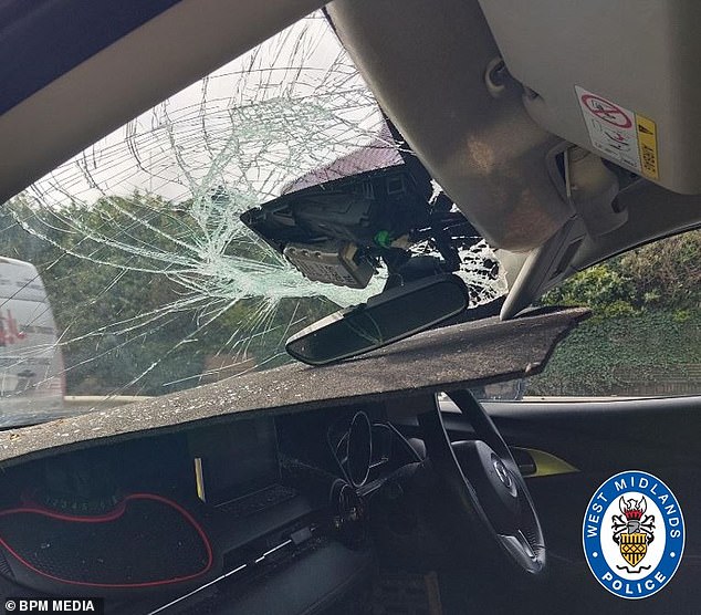 footbridge thugs hurl massive drain cover through windscreen of passing car as mazda occupants are lucky to escape with their lives