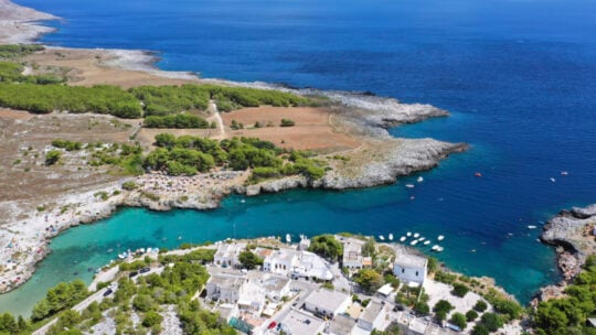 <p><span>Nestled 50 kilometers southeast of the colorful and floral Lecce, Porto Badisco stands out as a <a href="https://www.kindafrugal.com/hidden-gems-11-u-s-destinations-that-get-a-bad-rap/">hidden gem</a> in Puglia, cherished for its secluded charm. The coastline here is framed by gentle rock barriers, creating a swimming environment reminiscent of a vast, open-air aquarium, where the clarity of the sea allows for easy observation of small fish like anchovies and sardines gliding below the surface. Nearby, the traditional culinary experience awaits at Trattoria Le Taiate, where succulent lobster linguine and spaghetti with clams are served, offering a taste of the sea prepared by those who know it best. </span></p><p><span>Porto Badisco offers a unique blend of picturesque natural scenery and rich gastronomic pleasures, marking it a splendid spot for visitors.</span></p>