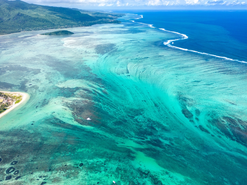 <p>As the sand is pushed over the edge of the submarine plateau, it gives the illusion of the underwater waterfall. The sands sink through the deep water down to the bottom of the ocean.</p>