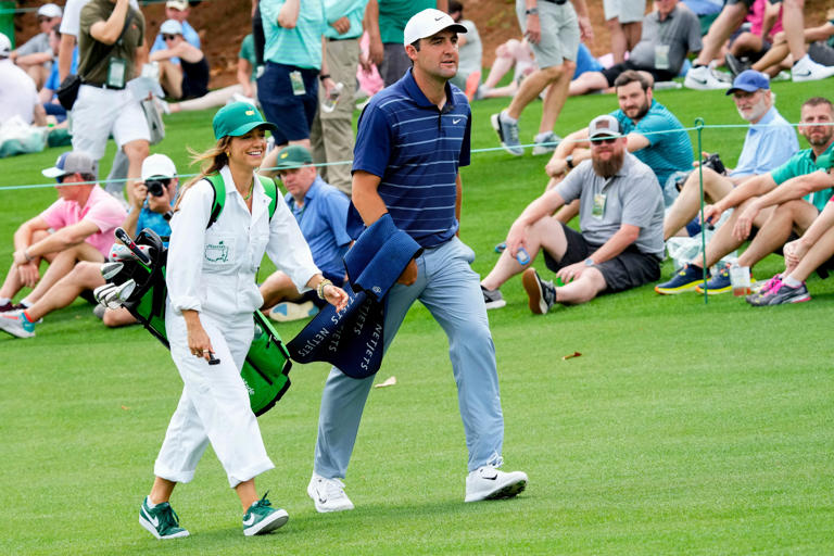 Scottie Scheffler walks the first fairway with his wife, Meredith, during the Par 3 Contest at The Masters golf tournament at the Augusta National Golf Club in Augusta, Ga., on April 5, 2023.