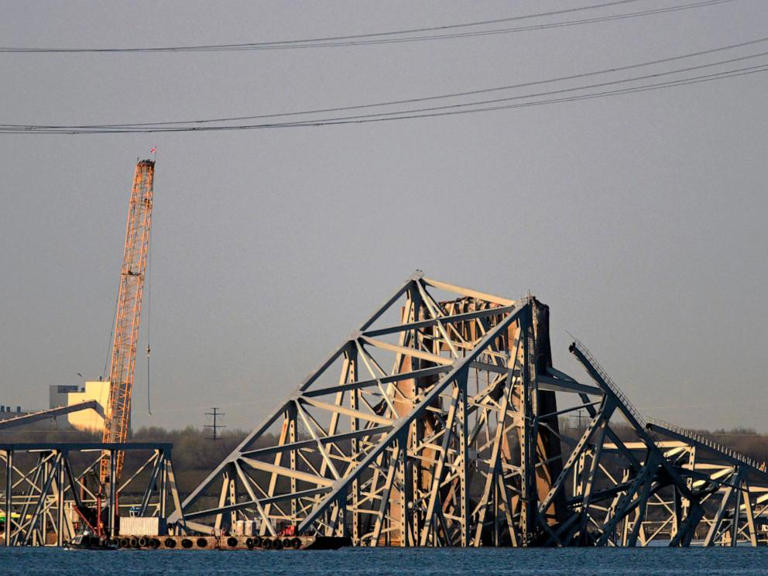 A crane is seen near the wreckage of the Francis Scott Key Bridge on Friday, March 29, 2024 in Baltimore.