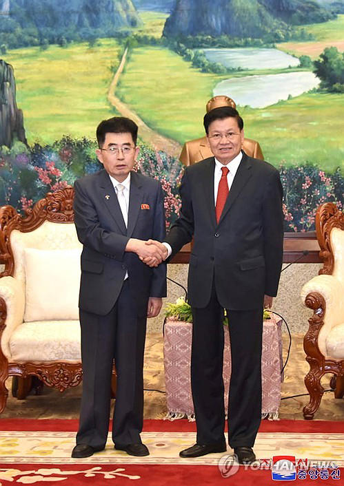 This photo, carried by North Korea's official Korean Central News Agency on March 31, 2024, shows Kim Song-nam (L), director of the international department at the North's ruling Workers' Party of Korea, shaking hands with Thongloun Sisoulith, the secretary general of the Communist Party of Laos. (For Use Only in the Republic of Korea. No Redistribution) (Yonhap)
