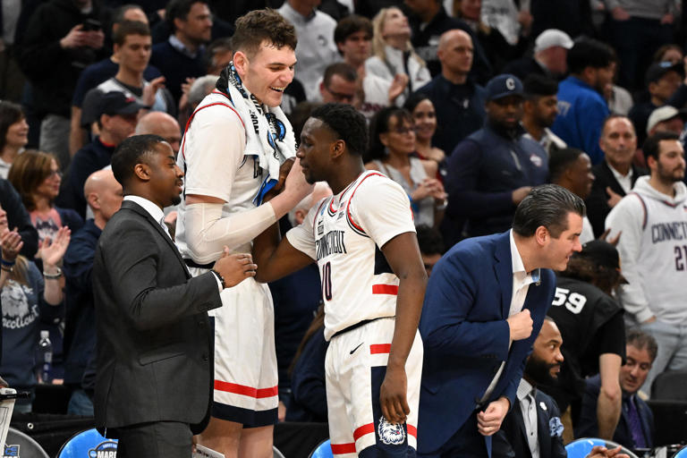 Mar 30, 2024; Boston, MA, USA; Connecticut Huskies center Donovan Clingan (32) reacts with guard Hassan Diarra (10) in the finals of the East Regional of the 2024 NCAA Tournament at TD Garden. Mandatory Credit: Brian Fluharty-USA TODAY Sports