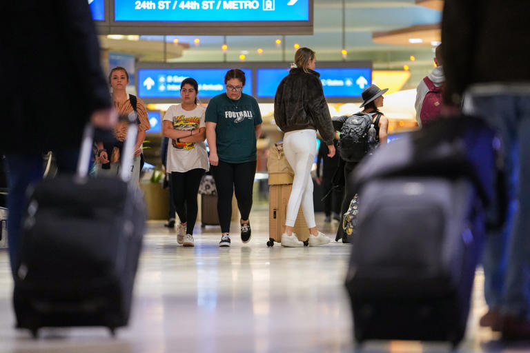 People walk through the departure level at Phoenix Sky Harbor International Airport on March 23, 2023, in Phoenix.