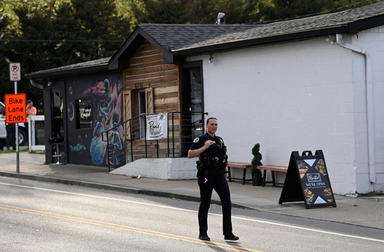 A Metro Nashville Police Department officer walks past the Roasted, a Salemtown restaurant, where customers were shot at a mass casualty event on Easter Sunday, March 31, 2024, in Nashville, Tenn.