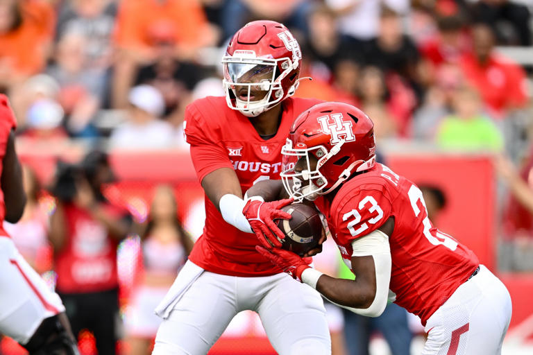 Nov 18, 2023; Houston, Texas, USA; Houston Cougars quarterback Donovan Smith (1) hands off the ball to running back Parker Jenkins (23) during the first quarter against the Oklahoma State Cowboys at TDECU Stadium. Mandatory Credit: Maria Lysaker-USA TODAY Sports