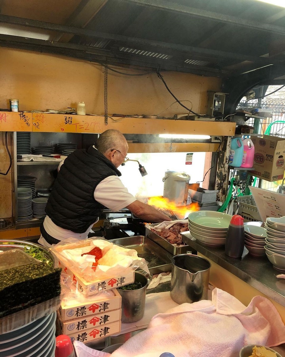 <p>Made world-famous by its appearance on Netflix’s <a href="https://www.youtube.com/watch?v=eI_LjETc_Ak&ab_channel=Netflix"><em>Street Food</em></a><em>, </em>Izakaya Toyo is one of the most beloved street food stalls in Osaka. Here, you’ll find jubilant cook and owner Toyo-san (pictured), preparing his signature flame-seared tuna with a blowtorch in hand. </p><p>Grab a seat, order a beer or sake and enjoy some of Izakaya Toyo’s <a href="https://www.atlasobscura.com/places/izakaya-toyo">many delicious offerings</a>: fresh salmon roe, sea urchin or the show-stopping seared tuna. </p>