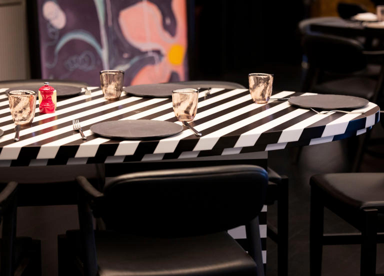A black and white oval table is a focal point in one of many rooms at Knife Italian in Irving/Las Colinas. By opening day, the slate-colored plates will be topped with hot pink napkins.
