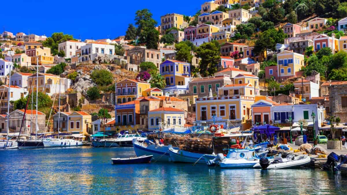 <p>Taking a ferry into the port of Ano Symi will be one of the most incredible experiences of your life. Colorful hotels and churches cover the hillside of the port and make it look almost like you’re coming into a city on the Amalfi coast.</p><p>This island is right off the coast of Turkey, so after you’ve visited it, you can head to Antalya, Turkey, to continue your beach vacation!</p>