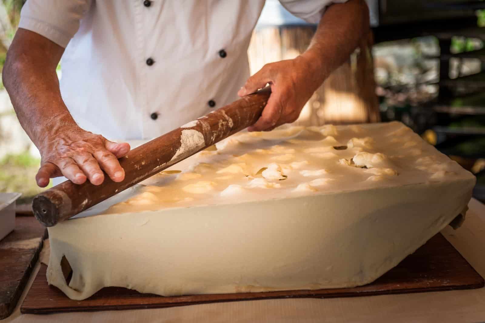 Image Credit: Shutterstock / lullaby7 <p><span>Indulge in focaccia di Recco, a Ligurian specialty that’s sure to tantalize your taste buds with its delicate layers of thin dough and creamy cheese. Unlike traditional focaccia, this version features two paper-thin sheets of dough filled with tangy stracchino cheese, creating a heavenly combination of crispy crust and molten cheese. Sample this culinary masterpiece at a local trattoria or bakery in Recco, where it’s been a beloved tradition for centuries.</span></p>