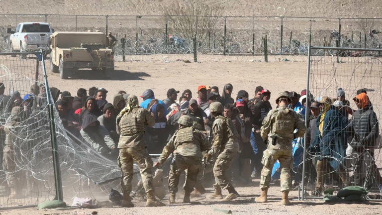 Over 100 migrants break through razor wire, knock down guards as they ...