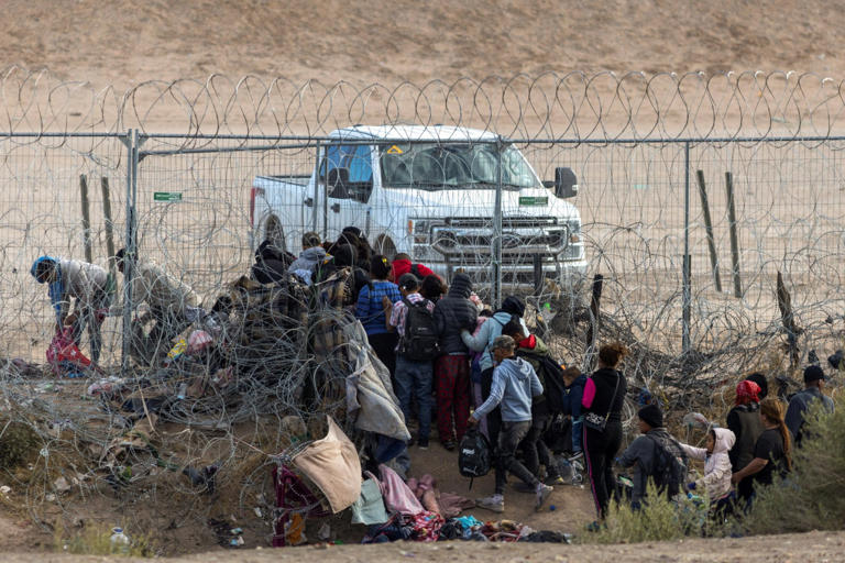 Migrants break through razor wire and knock guards to ground in border rush