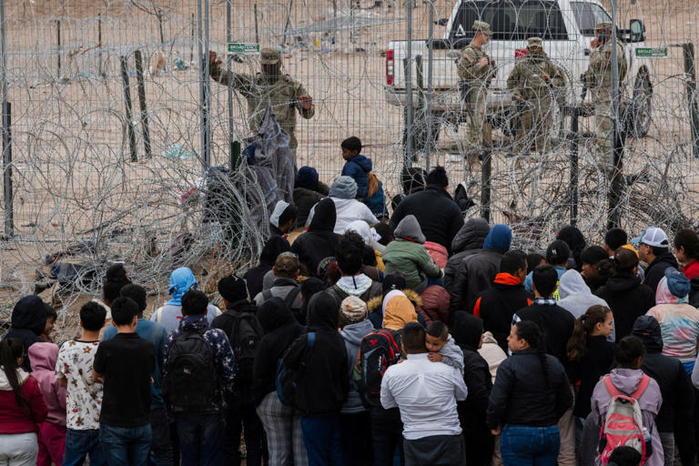 Migrants break through razor wire and knock guards to ground in border rush