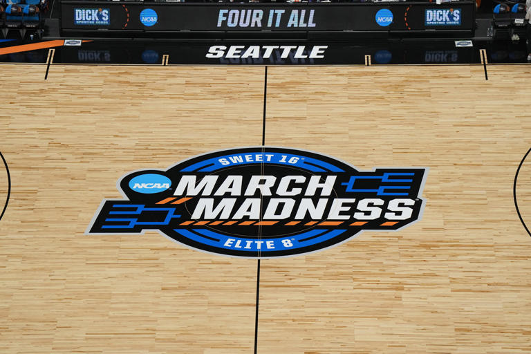 The March Madness Elite 8 and Sweet 16 logo is prominently displayed at center court during last year's NCAA women's basketball regional in Seattle.