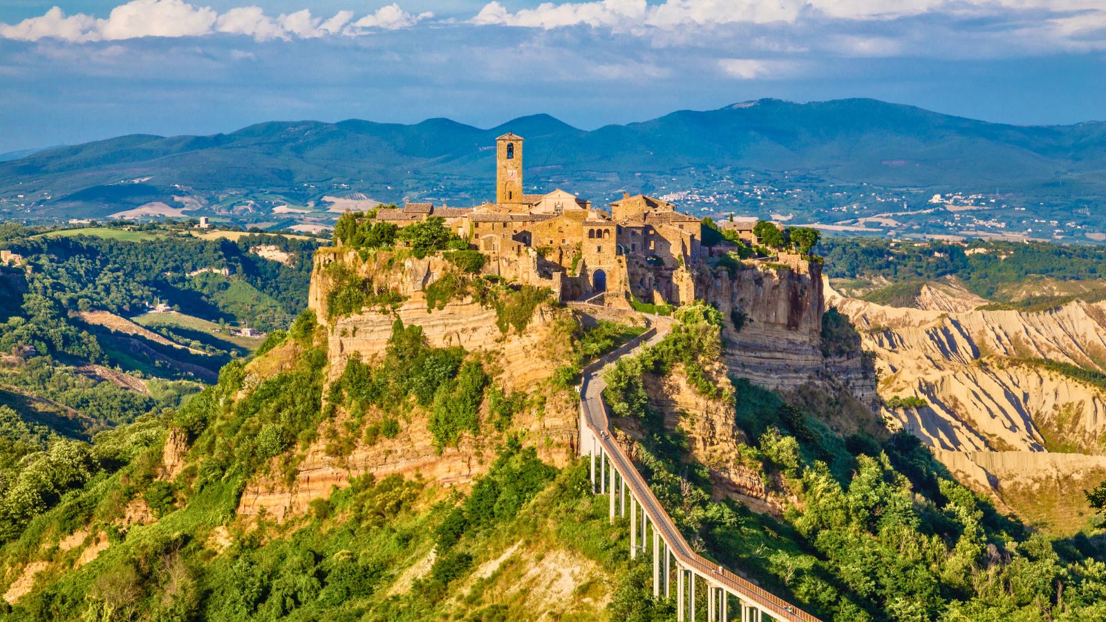 <p><span>You’re unlikely to visit anywhere else quite like Civita di Bagnoregio on your travels around Italy (or the world, for that matter). An ancient city perched atop a rocky knoll overlooking an enormous canyon, it is worth seeing simply for the location. Everything else is a bonus.</span></p><p><span>Access is via a footbridge that leads to a stone passageway first hewn 2,500 years ago by the Etruscans – an ancient entrance that acts as a portal to the Middle Ages. Civita seems frozen in time. Expect cobblestone streets, piazzas, palaces, and one point of historical intrigue after another.</span></p>