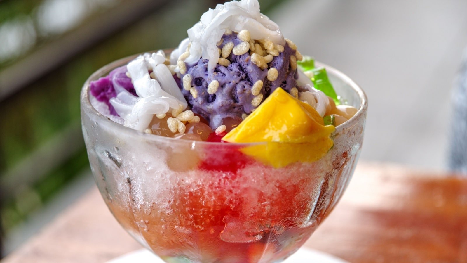 <p><span>In the Philippines, halo-halo is the go-to street food for a refreshing treat on a hot day. This colorful dessert consists of shaved ice, evaporated milk, various fruits, and sweet beans. It’s the perfect balance of sweetness and texture, making it a must-try in the Philippines.</span></p><p><span>The name halo-halo translates to “mix-mix,” and that’s precisely what you do before indulging in this delightful concoction. Each spoonful is a surprise, offering a distinct combination of flavors and textures, just like the diverse culture of the Philippines itself. Whether you’re a seasoned foodie or a curious traveler, the vibrant, multi-layered experience of devouring a halo-halo is a unique, delightful gastronomic adventure you’d not want to miss.</span></p>