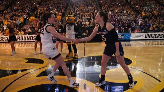 Caitlin Clark, #22 of the Iowa Hawkeyes, left, shakes hands with Kaitlyn Flanagan, #5 of the Holy Cross Crusaders, prior to tipoff during the first round of the 2024 NCAA Women's Basketball Tournament held at Carver-Hawkeye Arena on March 23, 2024, in Iowa City, Iowa. Rebecca Gratz/NCAA Photos via Getty Images