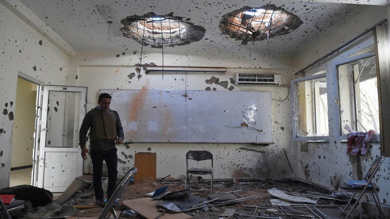 A journalist walks inside of a damaged class of the National Legal Training center, a day after gunmen stormed Kabul university in Kabul in November 2020. - Wakil Kohsar/AFP/Getty Images
