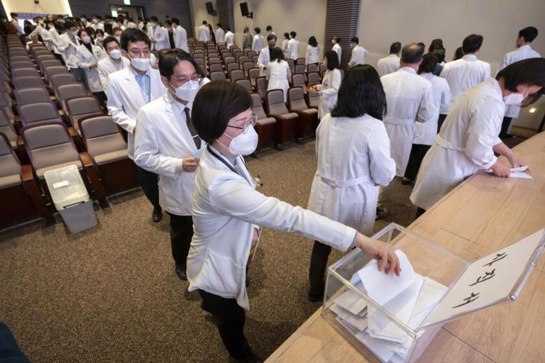 Medical professors queue to submit their resignations during a meeting at Korea University in Seoul on Monday. ((Yoon Dong-jin / Associated Press))