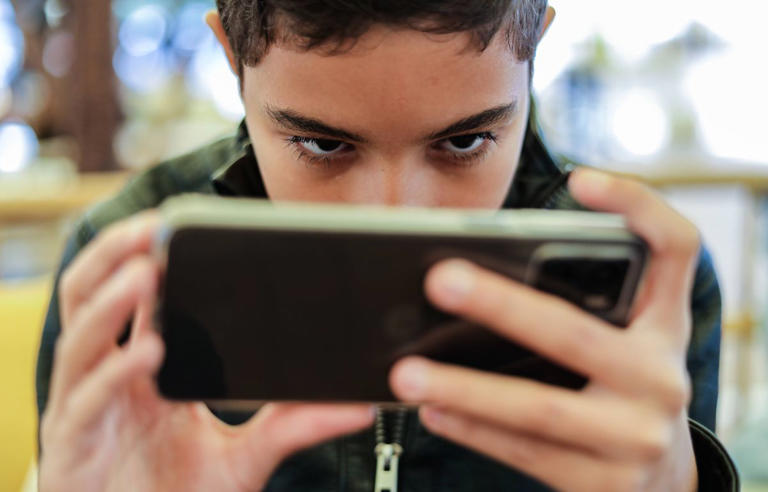 Un enfant jouant sur un smartphone.