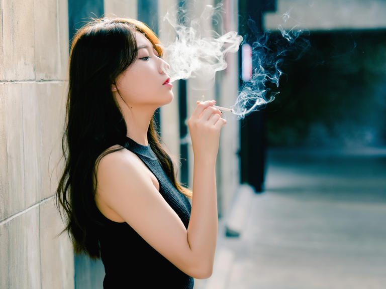 Photo of a woman smoking a cigarette. Women tend to find it harder to quit cigarettes, which might be down to the hormone estrogen.