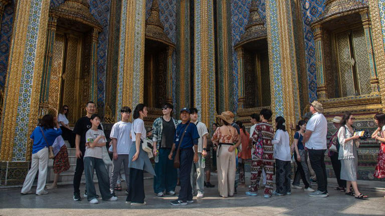 Chinese tourists visit the Temple of the Emerald Buddha in Bangkok. - Peerapon Boonyakiat/SOPA Images/LightRocket/Getty Images