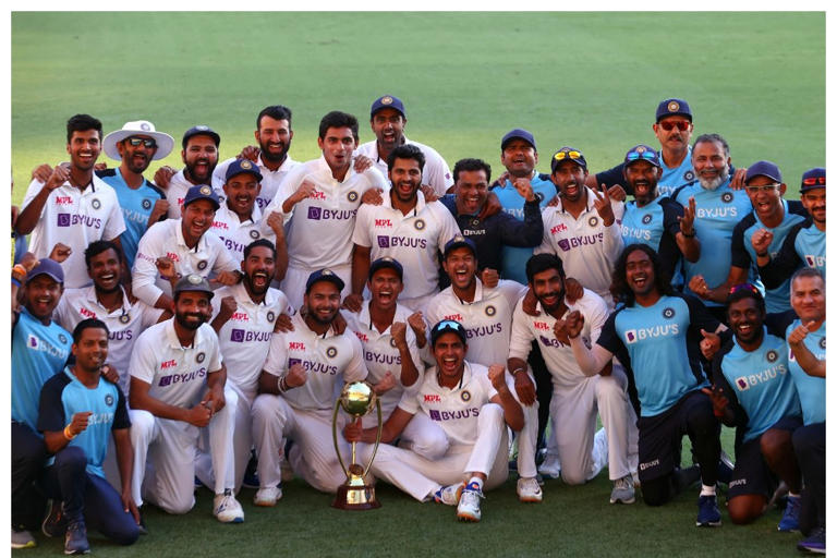 Indian players and officials celebrate with the winning trophy at the end of the fourth cricket Test match between Australia and India at The Gabba in Brisbane on January 19, 2021. / AFP