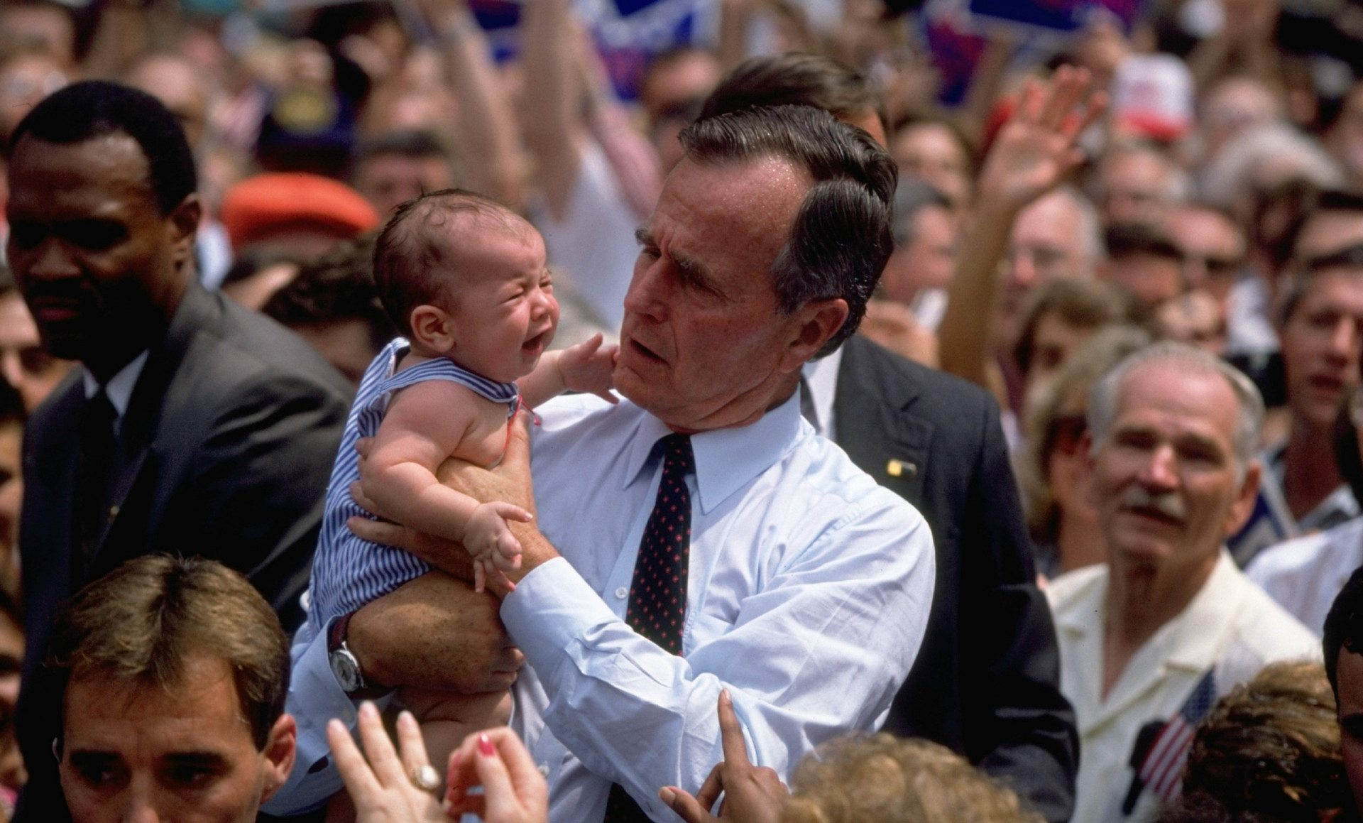 <p>George H. W. Bush schaut besorgt, als er am 27. August 1992 ein schreiendes Baby trägt.</p>